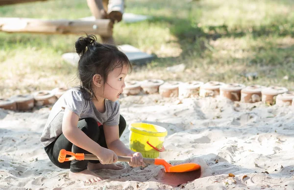 Söt asiatisk tjej spelar sand med solljus. — Stockfoto