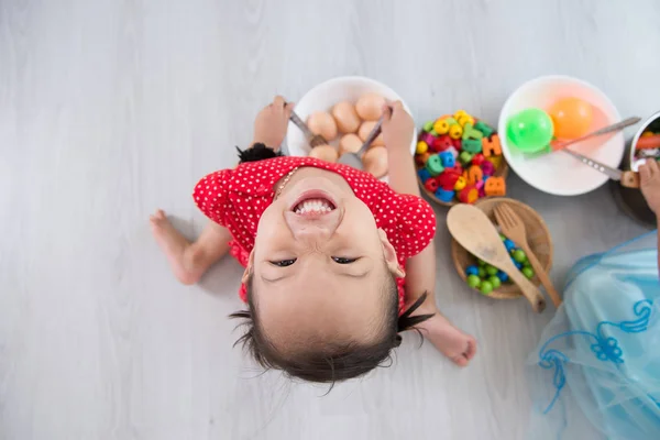 Happy asijské děti playig kuchař doma, pohled shora. — Stock fotografie