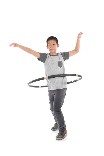 Asian boy playing with the hulahoop on a white background