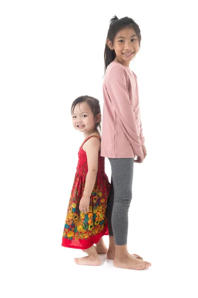 アジアの女の子および彼女の姉妹が一緒に立っている camer を見て — ストック写真