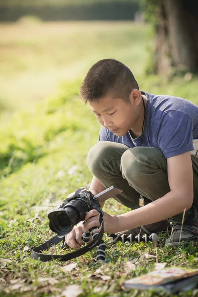 Asiático chico aprender a tomar la foto de la cámara en su mano con —  Fotos de Stock