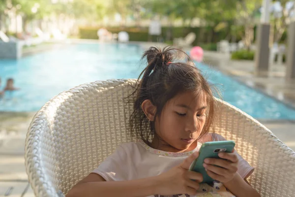 Asiatique fille à l'aide d'un smartphone avec fond de piscine. Techn — Photo
