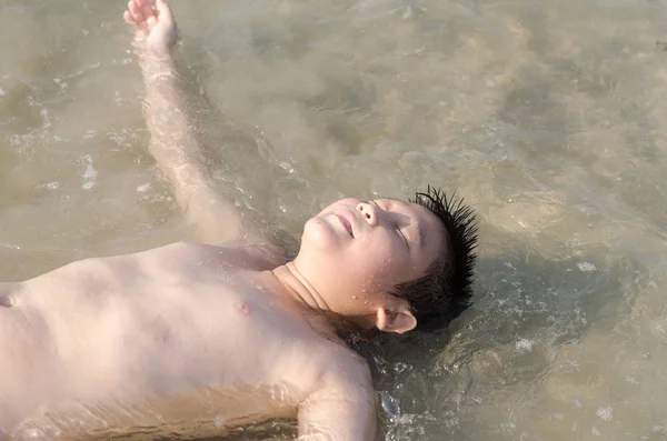 Szczęśliwy chłopiec azjatyckich układanie don morze zabawy latem. — Zdjęcie stockowe
