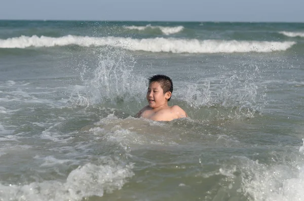 Szczęśliwy chłopiec azjatyckich przez brzegu plaży, zabawy. — Zdjęcie stockowe
