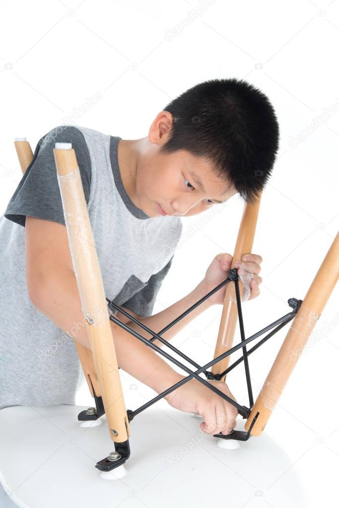Asian boy repair white chair isolated on white background.