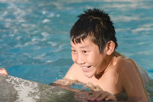 在游泳池中夏季时间享受快乐的亚洲男孩. — 图库照片