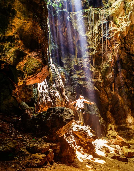 Desfoque de movimento Mulher em pé na caverna escura com os braços abertos desfrutar — Fotografia de Stock