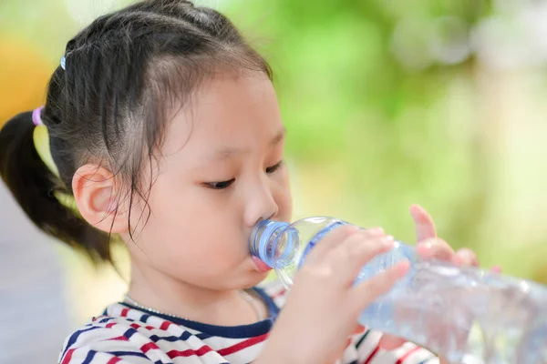 Little girl drinks mineral water — Stock Photo, Image