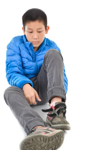 İnci üzerinde yalıtım mavi aşağı ve giyen mutlu Asyalı çocuk ayakkabı — Stok fotoğraf