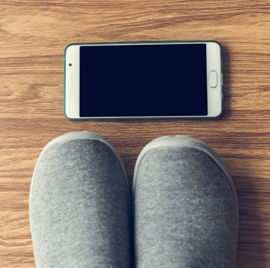 Evde smartphone ile katta gri spor ayakkabı. Yaşam tarzı co