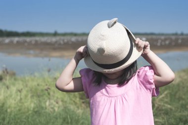 Yüzünü hasır şapka açık altında gizleme şirin Asyalı kız