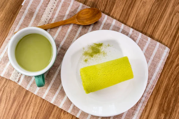 Torta de rollo con té verde sobre mesa de madera —  Fotos de Stock