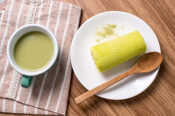 Torta de rollo con té verde sobre mesa de madera —  Fotos de Stock