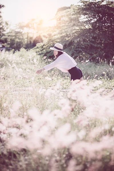 Aziatische tiener meisje met gras bloem met zonlicht. — Stockfoto