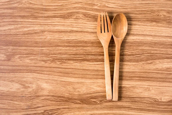 Cucchiaio e forchetta in legno con tavolo in legno . — Foto Stock