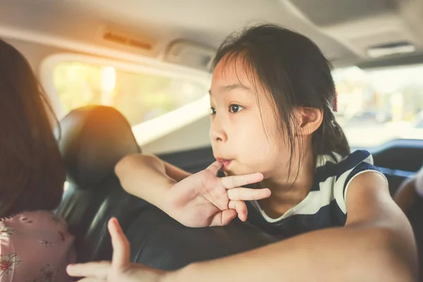 亚洲女孩坐在车里在旅行时，与她的家人 — 图库照片