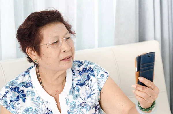 Asyalı kadın kıdemli Smartphone evde kullanma.