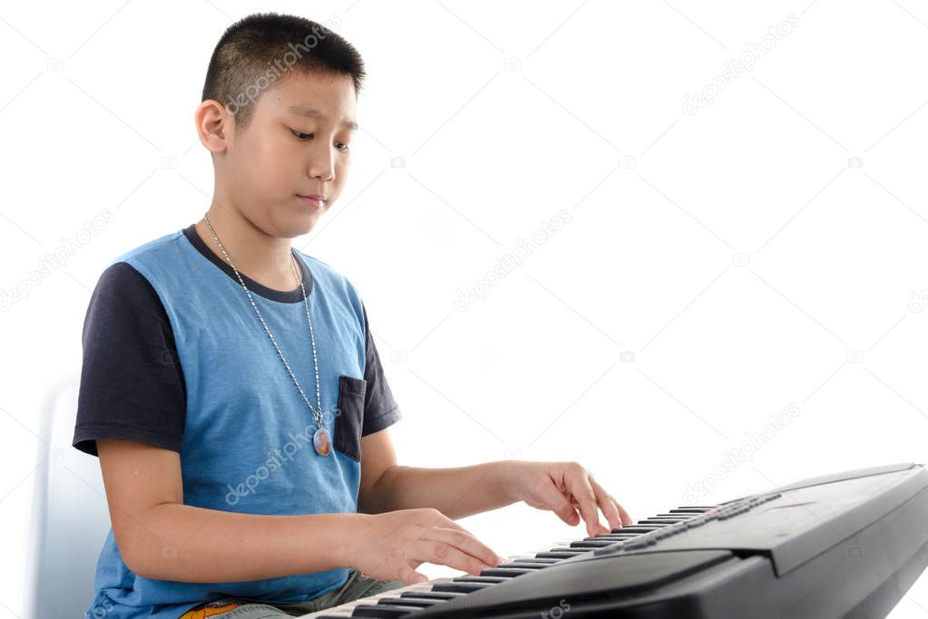 Asian boy playing keyboard on white background