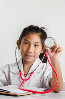 Kız doktor kılık kırmızı stetoskop üzerinde gri adam tutarak