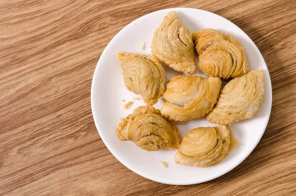 Snacks de puff al curry en plato blanco con fondo de madera . —  Fotos de Stock