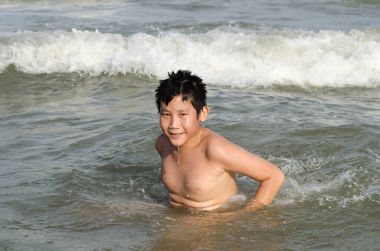 Asyalı çocuk zevk kumsalda güneşli bir günde