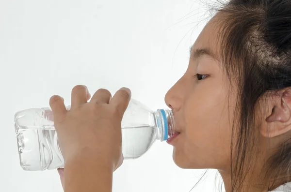Girl drinking a bottle of water on white background. — Stock Photo, Image