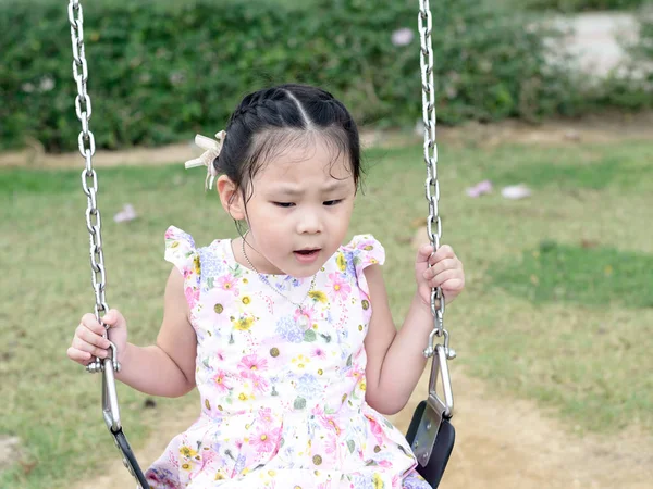 Entzückendes Mädchen hat Spaß auf einer Schaukel auf dem Spielplatz. — Stockfoto