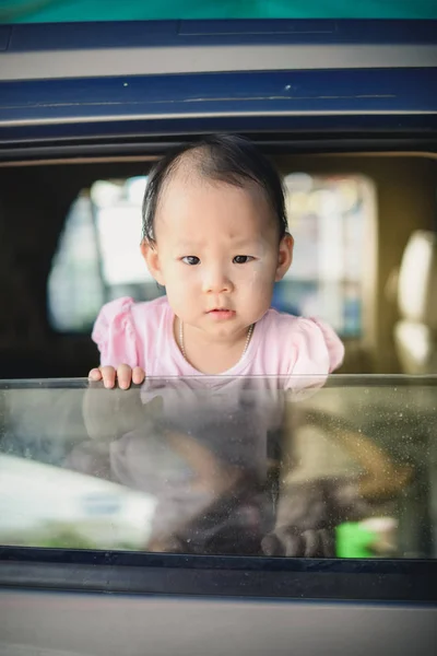 Asiatisches Kind im Auto und Beute aus dem Fenster — Stockfoto