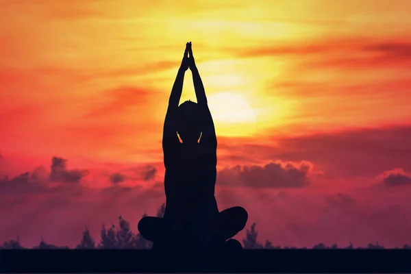 Silhouette yoga kvinna med solen stiga. — Stockfoto