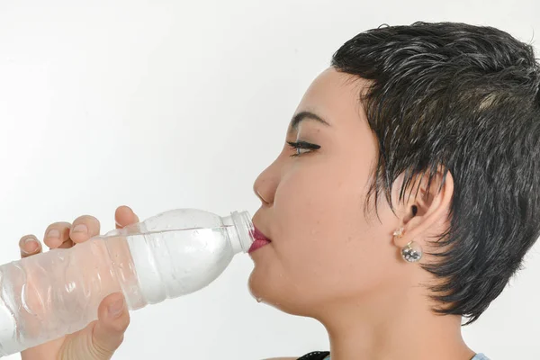 Slimme Aziatische vrouw drinken van een fles water, gezonde concept. — Stockfoto