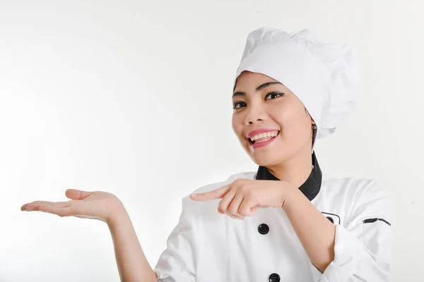 Mujer chef presentando menú.Linda chica chef en la campana muestra una h —  Fotos de Stock