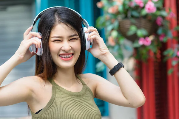 Beauty Woman wearing  braces and listening music in earphone on