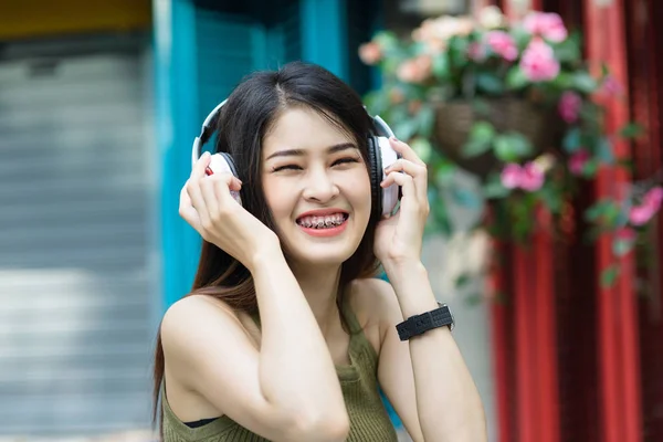 Beauté Femme portant des bretelles et écoutant de la musique dans l'écouteur sur — Photo
