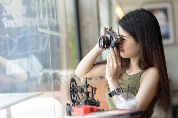 Boldog, gazdaság vintage kamera café ázsiai nő. — Stock Fotó