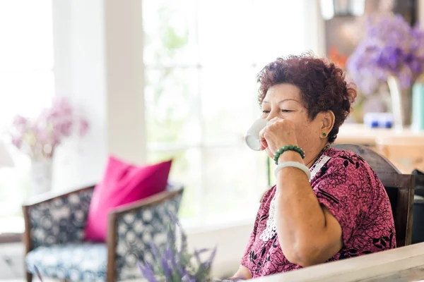 Gelukkig Aziatische senior vrouw thuis met het drinken van thee. Levensstijl concept — Stockfoto