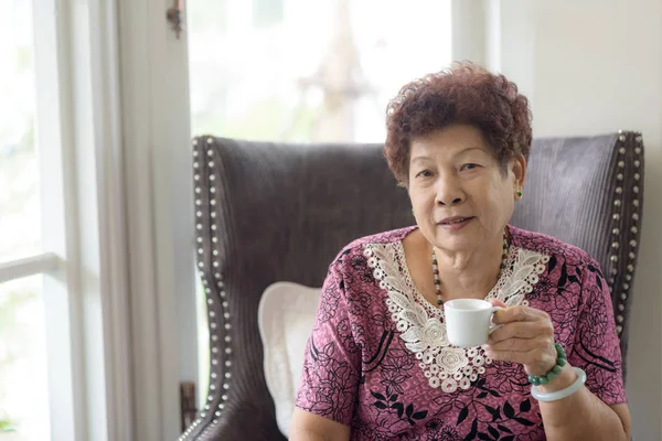 Gelukkig Aziatische senior vrouw thuis met het drinken van thee. Levensstijl concept — Stockfoto