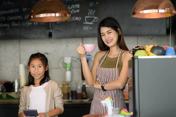 Selbstbewusster Barista. junge asiatische Unternehmerin und ihre Schwester stehen — Stockfoto