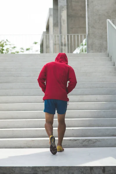 Urbaner Athlet, der nach oben rennt. Sportlicher Mann, der draußen trainiert — Stockfoto