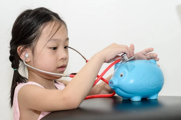 Girl doctor cure with piggy bank, money concept. — Stock Photo, Image