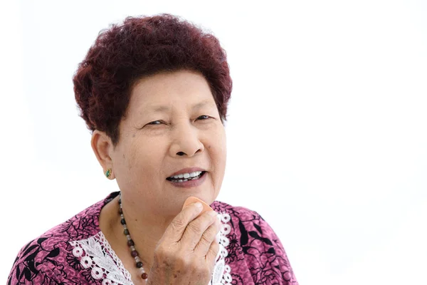 Aziatische senior vrouw make-up van haar gezicht op witte achtergrond. — Stockfoto