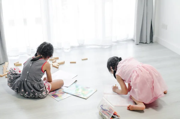 Baksidan av flickor ritar bild på golvet hemma. — Stockfoto