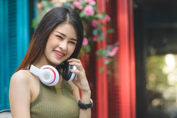 Mujer asiática feliz escuchando música con outdo de fondo de color —  Fotos de Stock