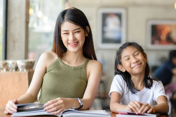 Feliz hermosa mujer leyendo un libro con su hermana, estilo de vida . —  Fotos de Stock