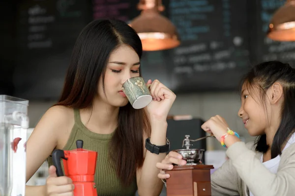 Schöne Barista bringt ihrer Schwester bei, wie man Kaffee zubereitet. — Stockfoto