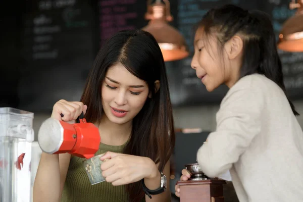 Schöne Barista bringt ihrer Schwester bei, wie man Kaffee zubereitet. — Stockfoto