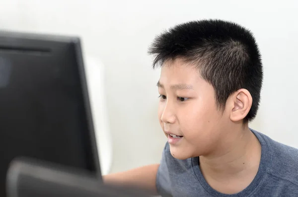 Menino asiático feliz jogando jogo de computador em casa . — Fotografia de Stock