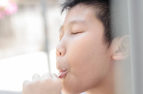 Happy Asian boy eating ice cream near window outdoor. — Stock Photo, Image