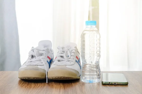 Спортивне взуття пляшка води і смартфон на дерев'яній підлозі, с — стокове фото