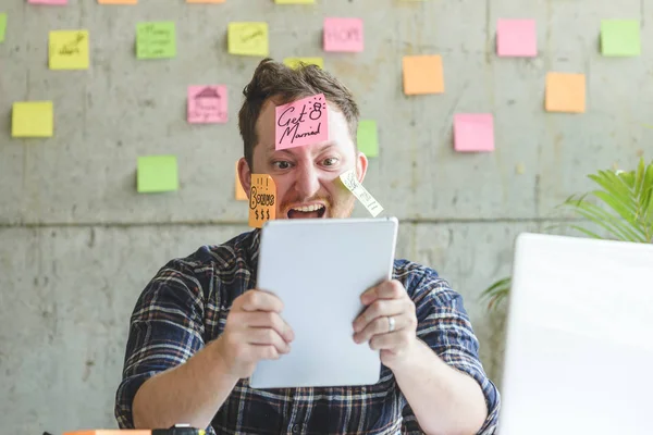 Стрессовый человек с сообщением на липких записках на лице на официальном языке — стоковое фото