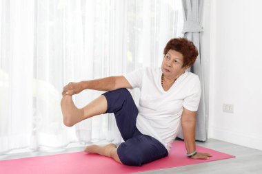 Evde egzersiz yaparak Asyalı kadın kıdemli.